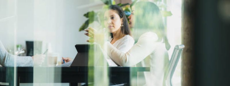 Two female listen to an employee.